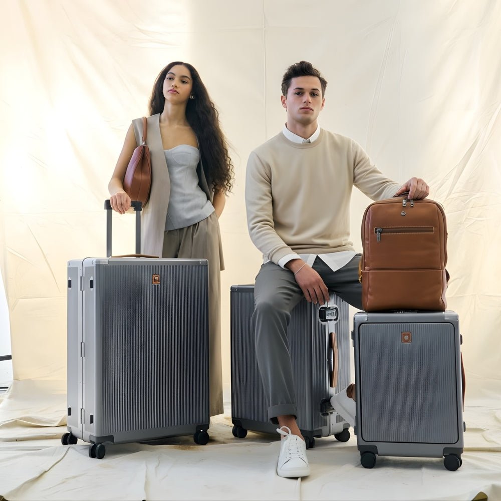 Two people with suitcases and a backpack on a neutral background