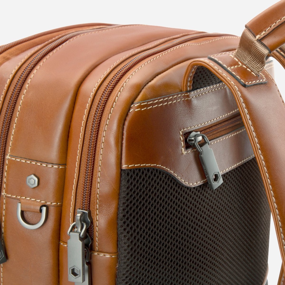 Close-up of the top zips and side mesh pocket on Jekyll and Hide tan leather everyday backpack