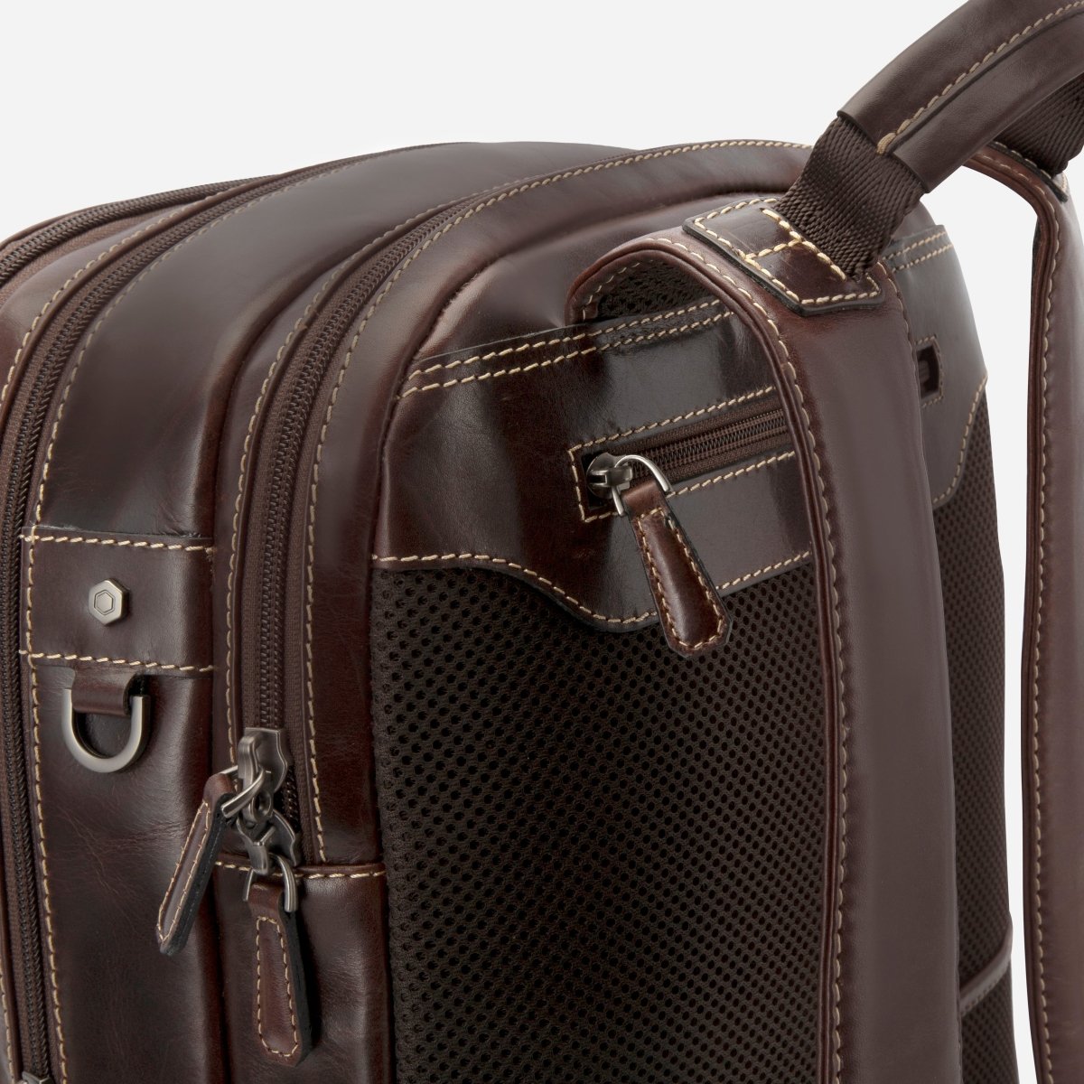 Close-up of the top zips and side mesh pocket on Jekyll and Hide dark brown leather everyday backpack