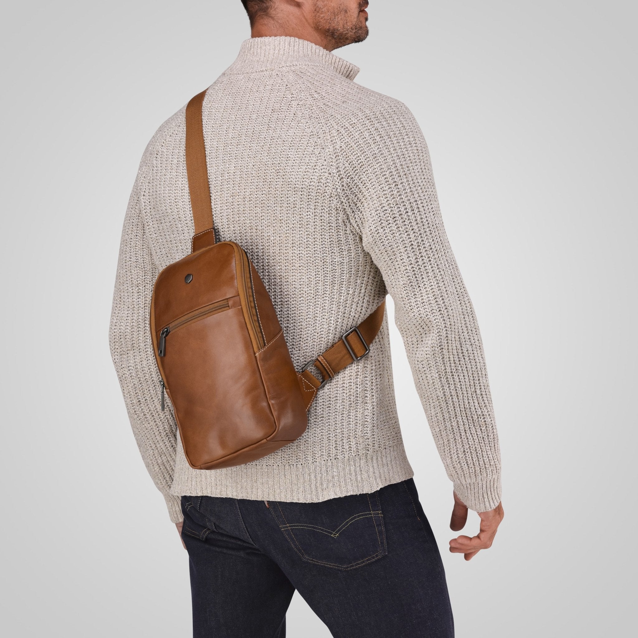Man wearing a Jekyll and Hide tan leather single-strap backpack across his back