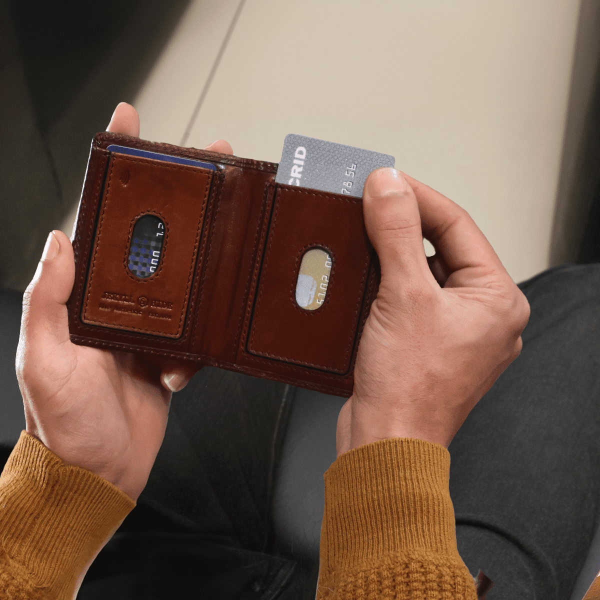 Man holding an open Jekyll and Hide dark brown leather elasticated card holder with cards