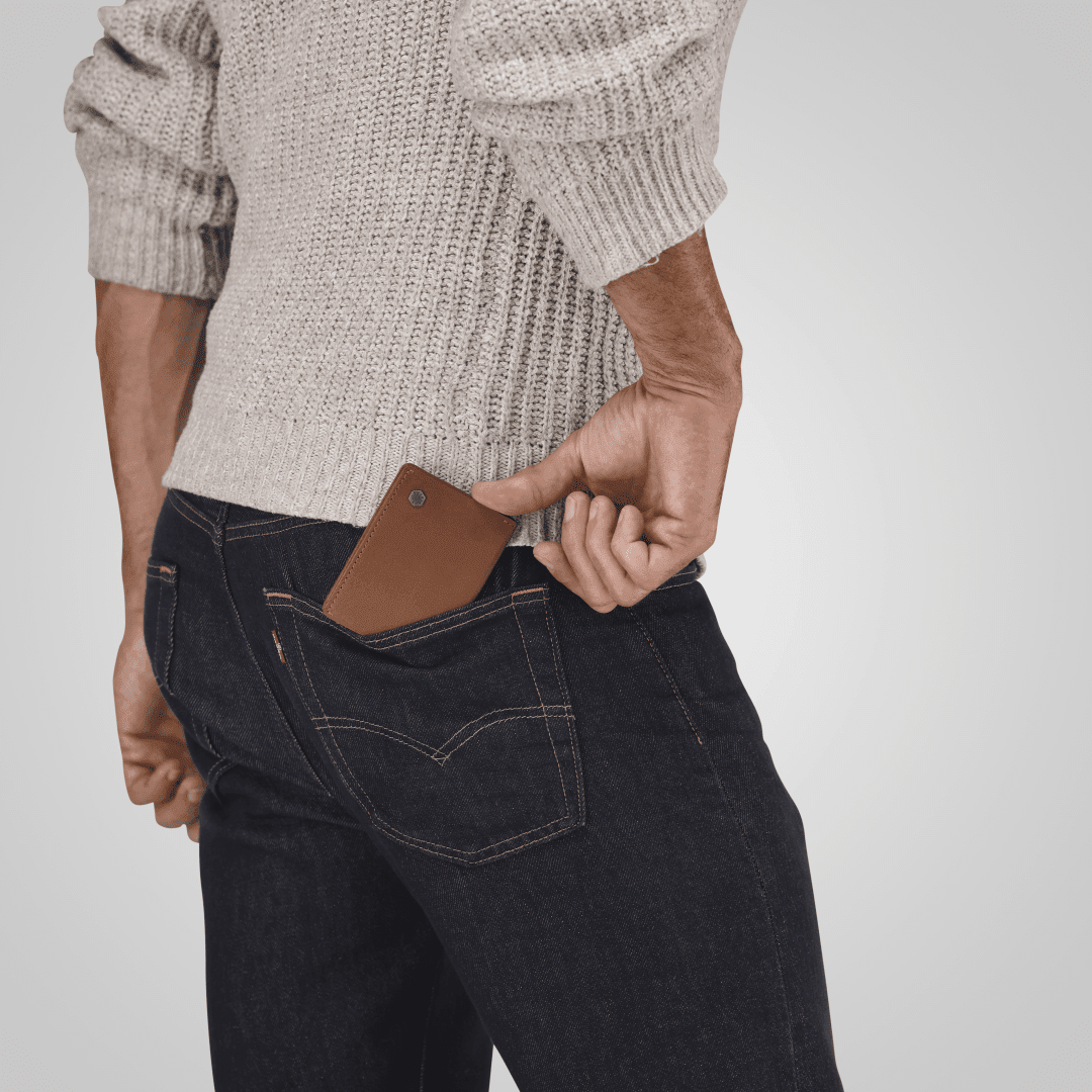 Man slipping a Jekyll and Hide tan leather elasticated card holder into his jeans pocket